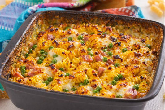 Pasta al forno con besciamella allo zafferano, prosciutto, piselli e formaggio